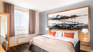 Edredón, escritorio, cortinas blackout y tabla de planchar con plancha