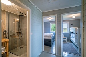 A modern bathroom with a glass-enclosed shower, a wooden vanity, and a visible towel rack.