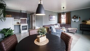 Una sala de estar moderna con una mesa de comedor, sofás y una zona de cocina.