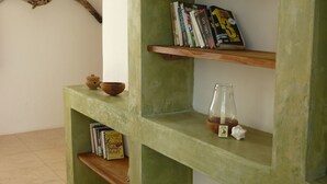A green console table with shelves, a branch decoration, and a small vase. - Kamili View Apartment in Zanzibar (Kiwengwa)