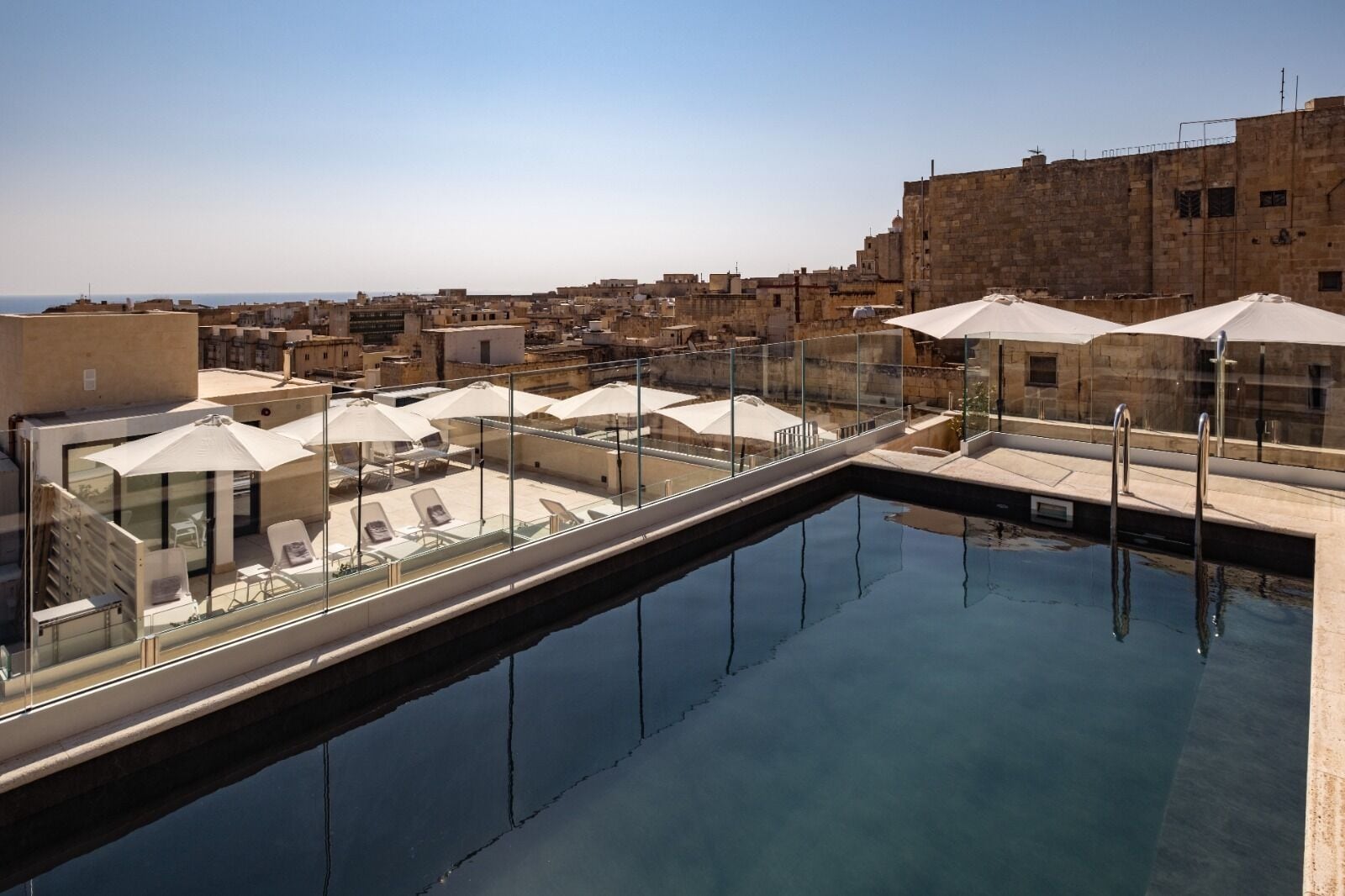 Een seizoensgebonden buitenzwembad en parasols bij het zwembad