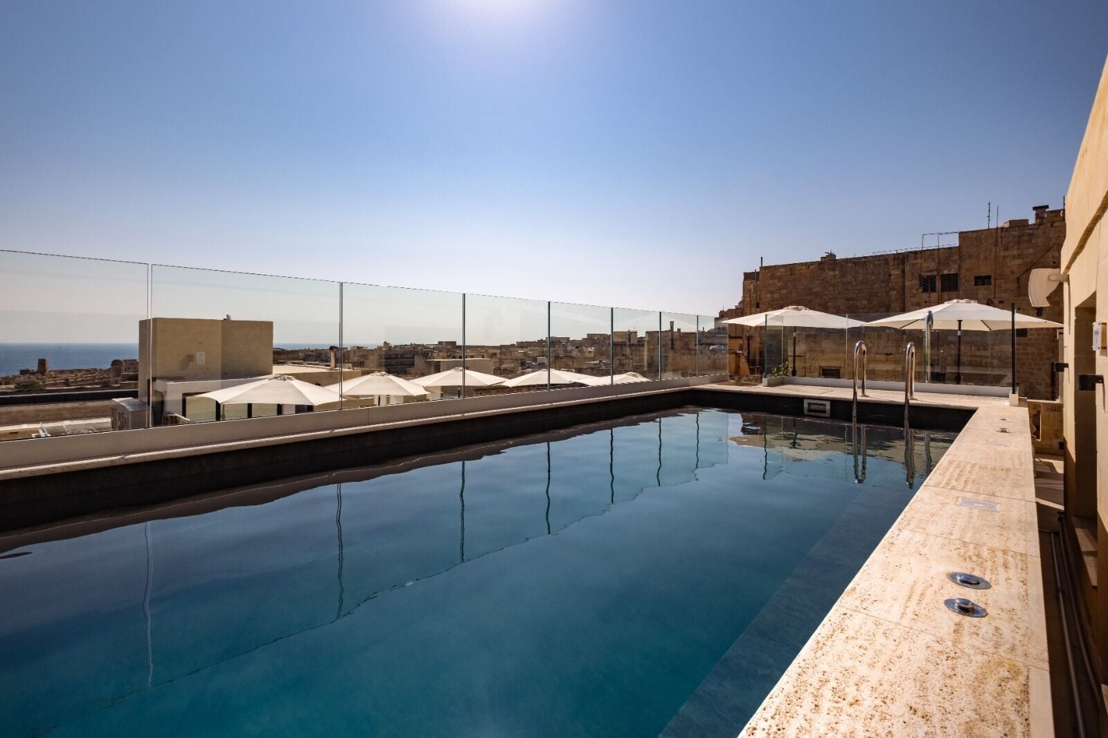 Una piscina al aire libre de temporada, sombrillas, tumbonas