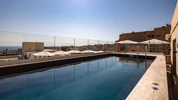 Een seizoensgebonden buitenzwembad en parasols bij het zwembad