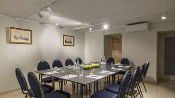 A conference room with a long table, chairs, and framed pictures on the walls.