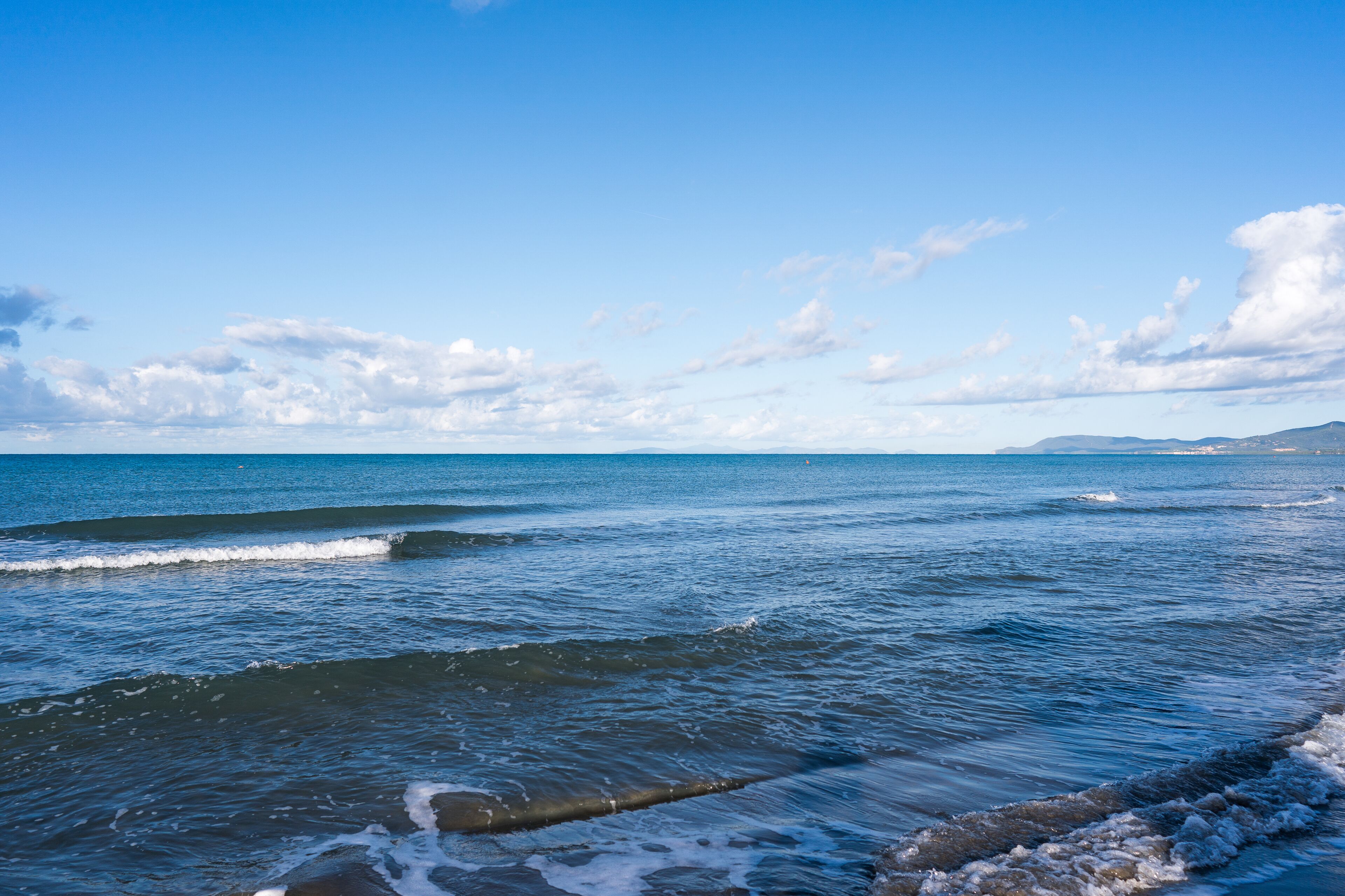 A coastal view with calm sea and clear sky.