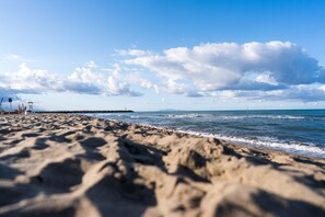 En strand med klart himmel og bølger.