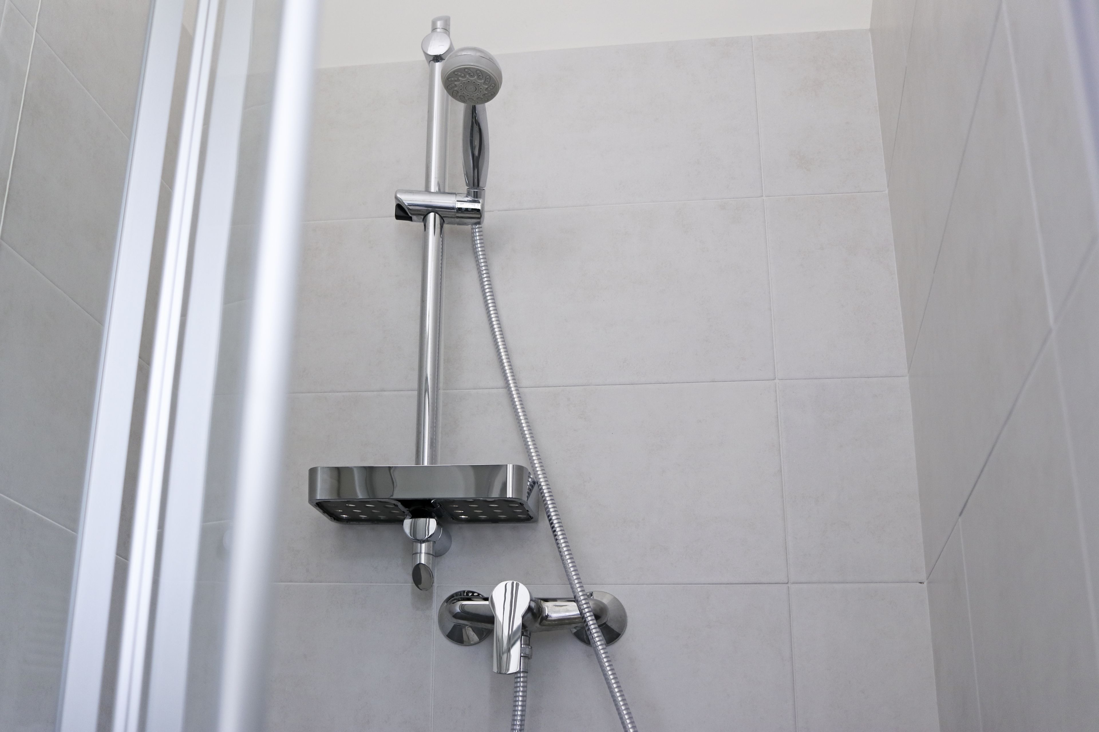 Eine Dusche mit Duschkopf und Handbrause.