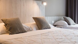 A hotel room with a large bed, two pillows, a headboard, and a wall-mounted light. - Hotel Terme di Frasassi (Genga)