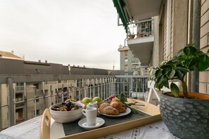 A balcony with a tray of breakfast items, including fruits, a croissant, and a cup. - notaMi -  Violet Home Loreto (Milan)