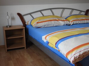 A bed with a metal frame, blue bedding, and striped pillows. - Maretsol Vacation House (Sveti Filip i Jakov)