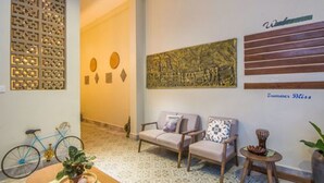 A room with a patterned floor, a sofa set, a decorative wall panel, and a bicycle. - Summer Bliss Boutique & Spa (Siem Reap)