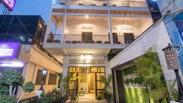 A multi-story hotel with a central entrance, balconies on each floor, and outdoor seating areas. - Summer Bliss Boutique & Spa (Siem Reap)