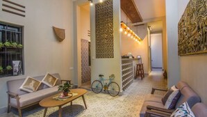A modern living room with a sofa, a coffee table, and a bicycle. - Summer Bliss Boutique & Spa (Siem Reap)