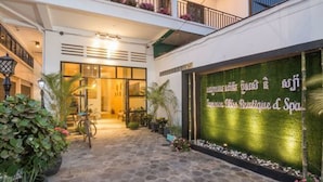 A spa boutique with a stone-paved entrance, potted plants, and a sign in a foreign language. - Summer Bliss Boutique & Spa (Siem Reap)