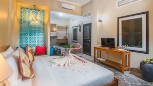 A hotel room with a bed, a TV, a wooden table, and a decorative wall panel. - Summer Bliss Boutique & Spa (Siem Reap)
