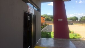 Entrada de un edificio con un letrero de recepción, una puerta que indica “RECEPTION” y un pilar rojo con un letrero de “RECEPTION”. 