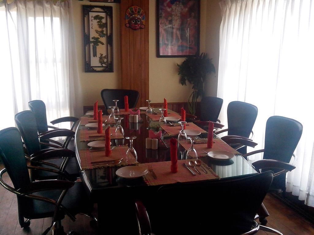 A dining area with a rectangular table set for six, surrounded by six chairs.