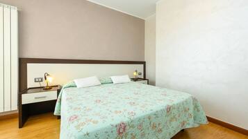 A bedroom with a bed, bedside tables, and a nightstand.