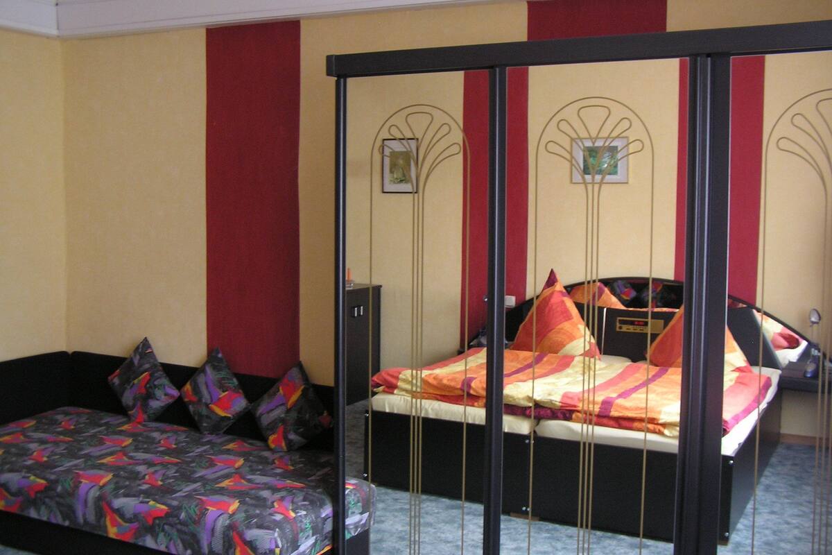 Ein Schlafzimmer mit Bett, Sofa und Kleiderschrank.