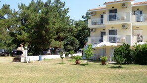 A multi-story building with balconies, a barbecue area, and potted plants. - Villa Iris (Thasos)