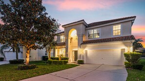 A two-story house with a garage, a driveway, and a well-maintained lawn. - Awesome! 6BR 4BA Luxury, Games, 2 Waterslides (Four Corners)