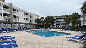 A pool area with blue lounge chairs and a clear pool. - Great View w/o Oceanfront Prices-3BR 2.5BA -  (Myrtle Beach)