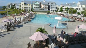 A resort with a large swimming pool, sun loungers, and beach umbrellas. - Bright, fun 5-bedroom townhouse in exclusive gated community with free WiFi, an indoor/outdoor pool, private bayside beaches, a restaurant, and more! (Ocean City)