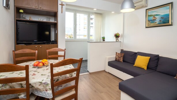 Un espacio habitable compacto con comedor, kitchenette y sofá.
