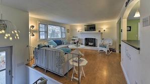 Un salon chaleureux avec une cheminée, un canapé et un coin repas.