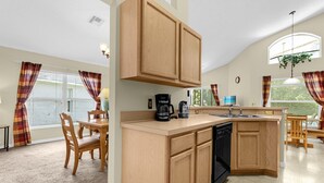 A kitchen with wooden cabinets, a coffee maker, and a dishwasher. - 1061 Lake Berkley 4 Bed with Pool (kissimmee)