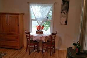 Enjoy meals in this inviting dining area with a table for two, a potted plant, and a beautiful view.