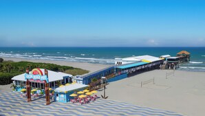 A beach pier with a sign reading "Cocoa Beach Pier" and a restaurant.