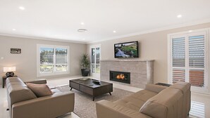 A living room with a fireplace, a television, and a sofa. - Best Cellar - The VIntage Holiday Houses (POKOLBIN)