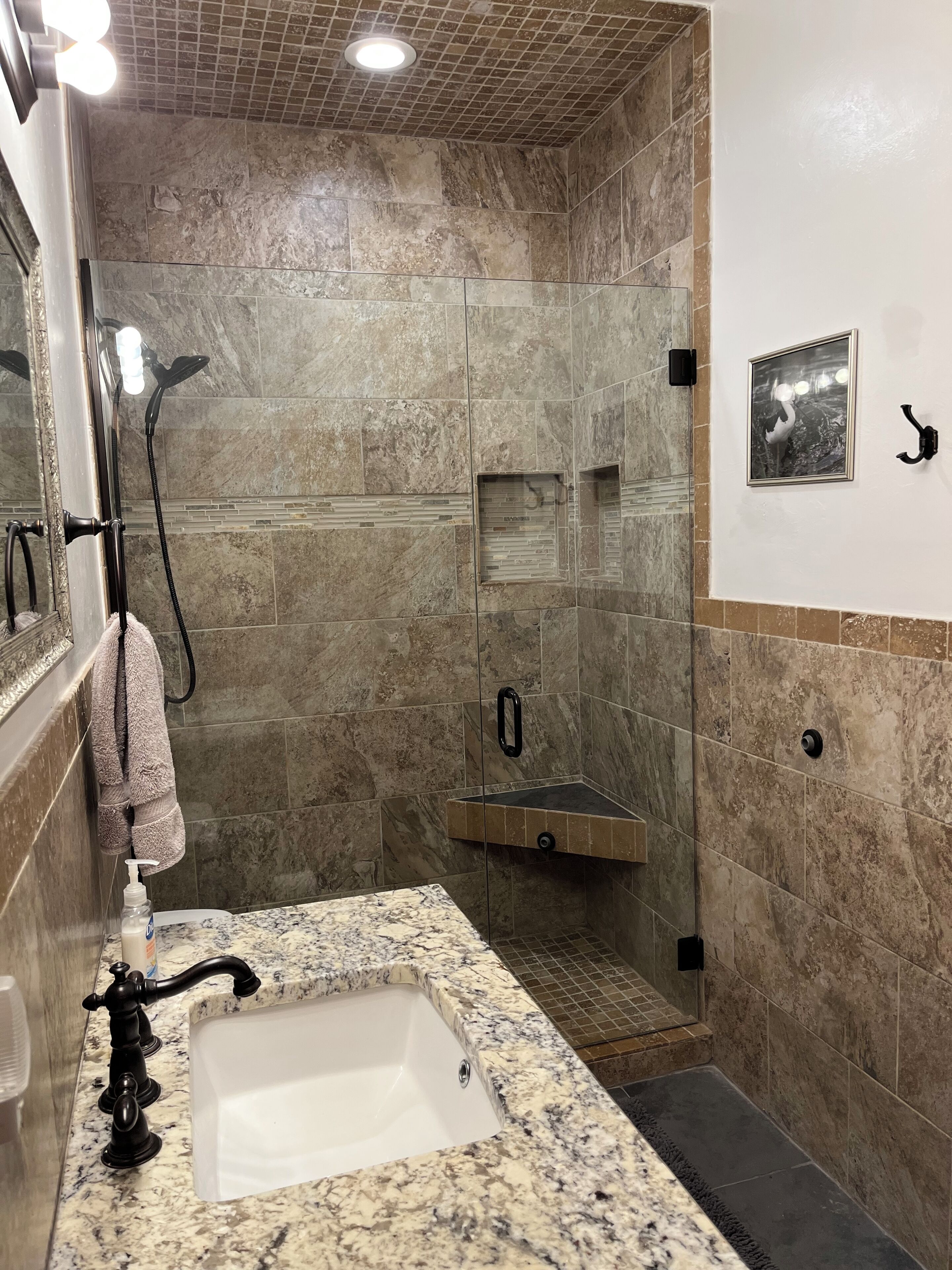 A bathroom with a shower, sink, and a towel rack.