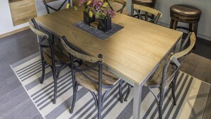 A modern kitchen with wooden cabinets, a granite countertop, and a built-in island with stools. - Great 2 bed townhouse. This is the best location in Ketchum! (Ketchum)