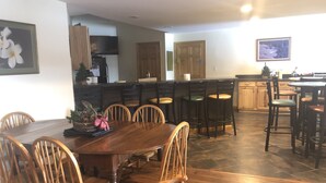 A spacious kitchen with a central island, wooden chairs, and a dining table. - Beautiful valley views & next to Big Spring State Park (Doylesburg)