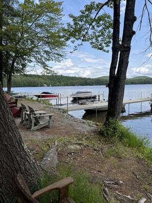 A lakeside campsite with picnic tables, a dock, and boats. - A beautiful lake view cabin on Friends Lake (Chestertown)