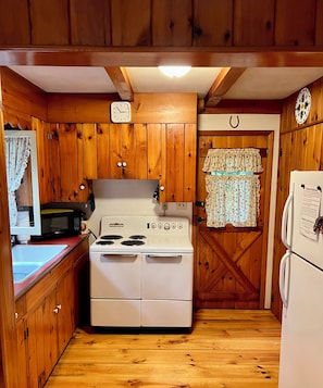 Enjoy cooking in this fully equipped kitchen with a stove, microwave, sink, and refrigerator.
