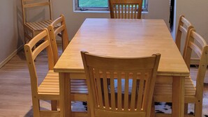 A dining area with a wooden table and chairs, a window with a view of greenery, and a cowhide rug on the floor. - Snowcreek Resort Vacation Rental 617 (Mammoth Lakes)