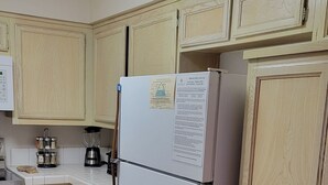 A kitchen with wooden cabinets, a refrigerator, a coffee maker, and a stove. - Snowcreek Resort Vacation Rental 617 (Mammoth Lakes)