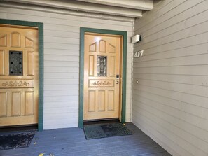 A wooden front door with a green frame, a small window with decorative glass, and a number '617' on the wall. - Snowcreek Resort Vacation Rental 617 (Mammoth Lakes)