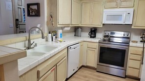 A kitchen with a stainless steel oven, a microwave, a dishwasher, and wooden cabinets.