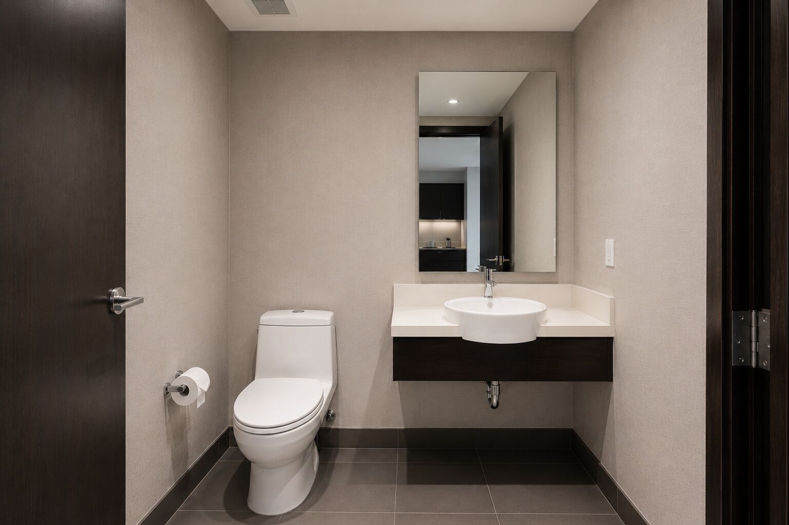 Et moderne badeværelse med toilet, vask og spejl.