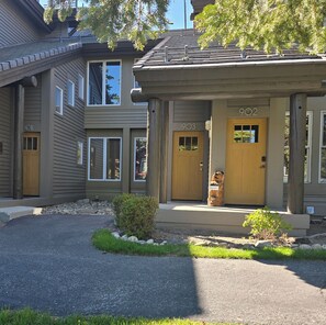 A two-story building with a porch, numbered doors, and a small bear statue. - Snowcreek Resort Vacation Rental 903 (Mammoth Lakes)