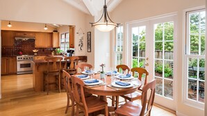 Une cuisine spacieuse dotée de meubles en bois, d’un îlot central et d’un coin repas avec de la vaisselle bleue et blanche.