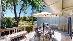 Une terrasse dotée de mobilier d’extérieur, d’une table et d’un parasol.