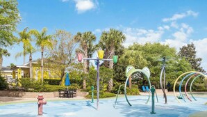 An outdoor exercise area with exercise equipment, a blue water feature, and a building in the background. - Bahama Bay- 3 bedroom condo with amenities (Davenport)