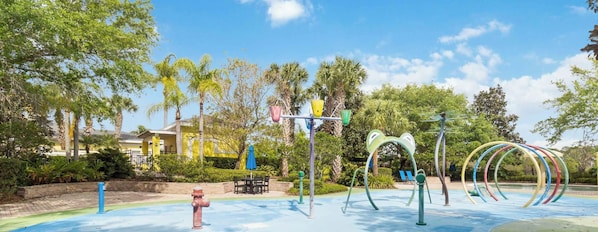 A playground with exercise equipment, a blue fire hydrant, and a building in the background. - Bahama Bay- 3 bedroom condo with amenities (Davenport)