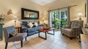 A living room with a sofa, armchair, and a table with a lamp. - Bahama Bay- 3 bedroom condo with amenities (Davenport)