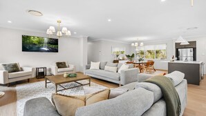 Una sala de estar moderna con un sofá, una mesa de centro y una zona de comedor con sillas y una mesa.